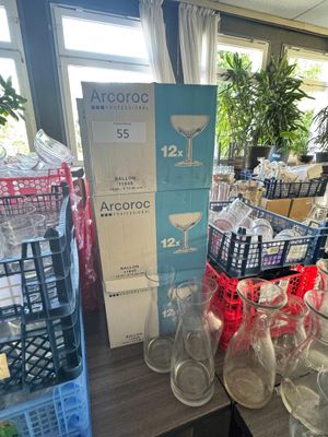 Des bouteilles et des verres sont empilés sur une table dans un magasin.