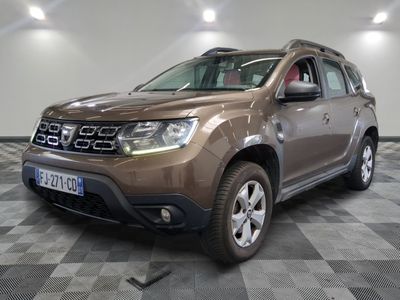 une photo d'une dacia marron garée sur un sol en damier