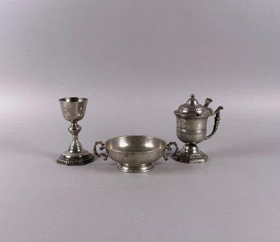 two silver cups and a bowl on a white surface
