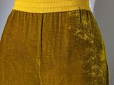 the back view of a woman ' s pants with a yellow belt