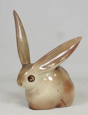 a small ceramic rabbit sitting on a white surface