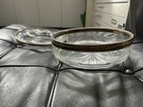 a glass bowl sitting on top of a black leather ottoman