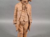 wooden statue of a man with a hat and a jacket