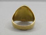a close up of a gold ring on a white surface