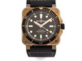 La montre noire et dorée est montée sur un bracelet en cuir noir