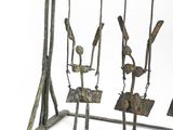 a metal sculpture of people on a swing set