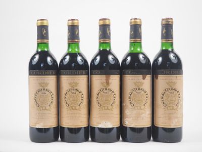 quatre bouteilles de vin sont alignées sur une surface blanche