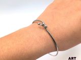 someone is wearing a silver bracelet with a star design on it
