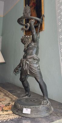 une statue représentant un homme tenant un plateau posé sur une table