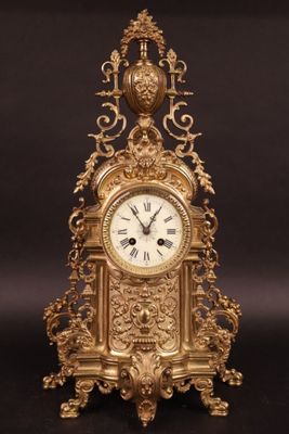 une horloge dorée posée sur une surface noire