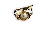 an image of a gold wrist watch with a chain around it