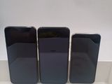 trois iPhones noirs posés sur un comptoir blanc