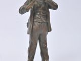 bronze statue of a man with a hat and jacket on a rock