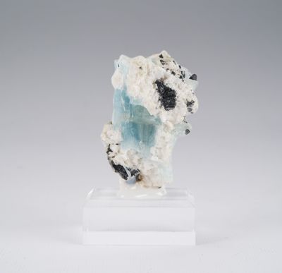 a white and blue piece of rock with black and white crystals