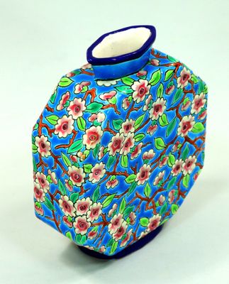 un vase bleu avec des fleurs posé sur une table