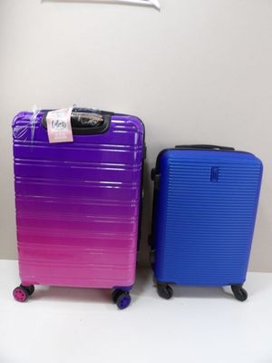 purple and blue suitcases sitting next to each other on a table