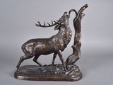 statue d'un cerf sur un rocher, avec un arbre en arrière-plan