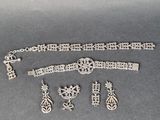 an assortment of silver jewelry including a bracelet, bracelet, and broochet