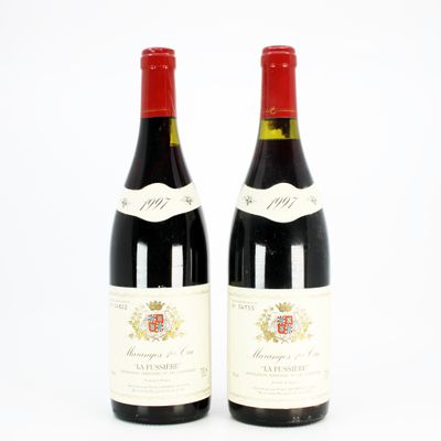 two bottles of red wine sitting next to each other on a white surface