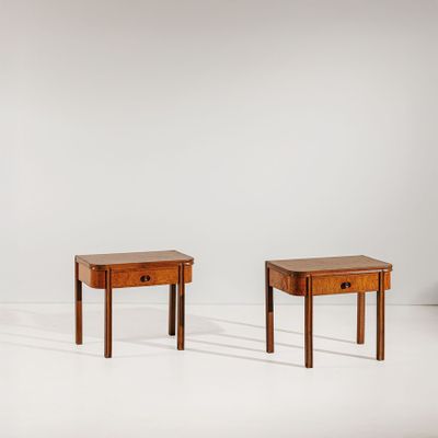 deux petites tables avec des tiroirs de chaque côté, dans une pièce blanche