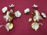 two wall sconces that have flowers on them