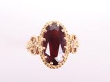 Gros plan sur une bague contenant une pierre rouge
