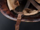 a helmet that has a leather strap on it