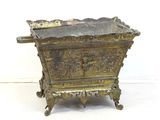 jardinière en laiton ancien avec un motif ouvragé, posée sur un socle, sur fond blanc