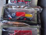 trois camions miniatures rangés dans des sacs en plastique sur une table