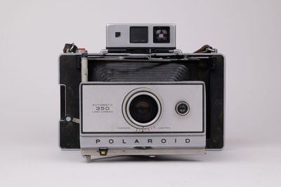 un appareil photo Polaroid posé sur une table blanche