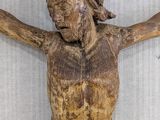wooden statue of a man with a cross on a white background