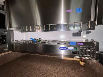 une grande cuisine avec de nombreux appareils en acier inoxydable