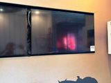 two large televisions mounted on the wall in a room