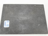 an old metal plate with a sticker on it on a white surface