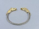 a close up of a bracelet with two horses on it