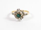 un gros plan d'une bague en or ornée d'une pierre verte au centre
