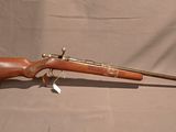 un vieux fusil avec un canon en bois et un étui en cuir