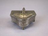 an old silver box with a lid sitting on a table