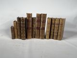 six vieux livres empilés les uns sur les autres sur une surface blanche