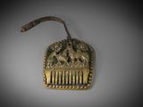 an old brass comb with a design of horses and people on it