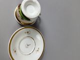 a cup and saucer sitting on a table next to each other