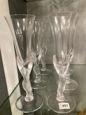 quatre verres à vin posés sur une étagère en verre dans une vitrine en verre