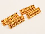 a set of four gold plated metal rollers on a white surface