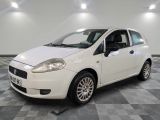 la petite voiture blanche est garée sur un sol en damier