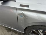a car that has been dented and has a sticker on it