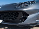 the front end of a silver sports car parked on the side of the road