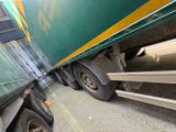 a green semi truck with a yellow stripe on the side of it