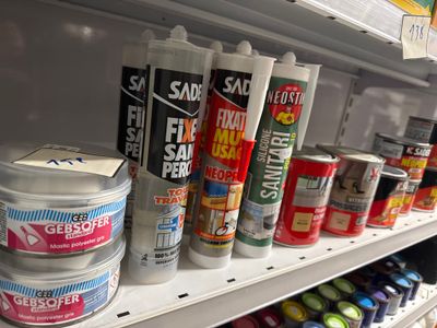 de nombreux pots de peinture sur une étagère dans un magasin