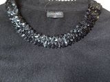 a close up of a black shirt with a necklace on it