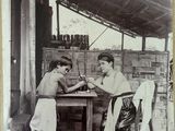 an old black and white photo of two men sitting at a table